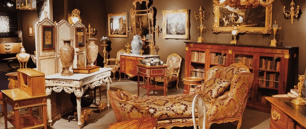 Intérieur d'antiquaire : mobilier d'époque, tableaux dans leurs cadres dorés et objets d'art